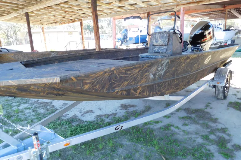 Slide: The Image of 2025 G3 Gator Tough 18 CC boat with camouflage design on a trailer. - 3