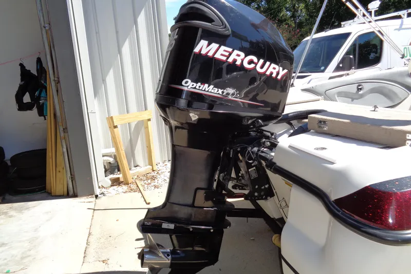 Slide: The Image of Mercury OptiMax outboard motor on a 2011 Nitro 290 boat, parked outdoors. - 23
