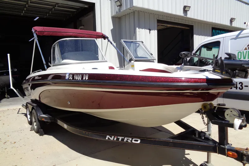 Slide: The Image of 2011 Nitro 290 boat with maroon and white design on a trailer. - 25