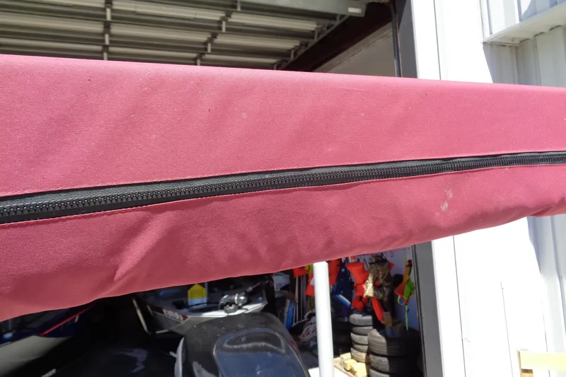 Slide: The Image of Red boat cover with zipper on a 2011 Nitro 290 in a garage. - 30