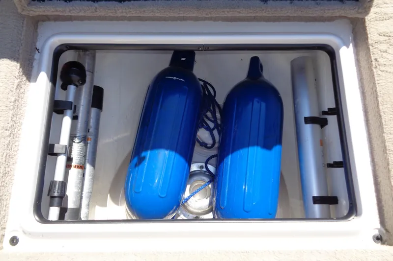 Slide: The Image of Storage compartment of a 2011 Nitro 290 boat with blue fenders and equipment. - 31