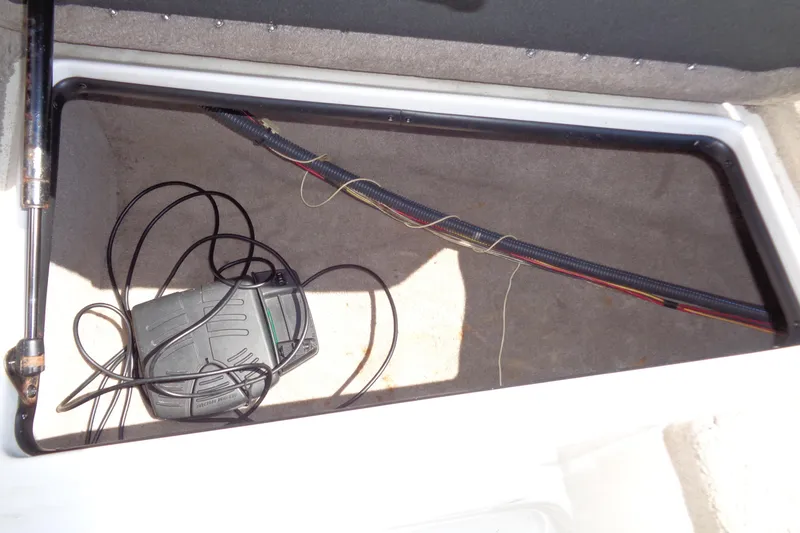 Slide: The Image of Open storage compartment in 2011 Nitro 290 boat with wiring and pedal. - 32
