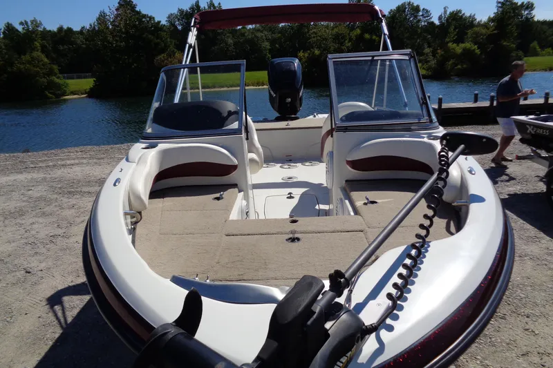 Slide: The Image of 2011 Nitro 290 boat docked by a lake, featuring spacious seating and modern design. - 4
