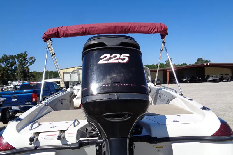 Slide: The Image of 2011 Nitro 290 boat with 225 horsepower engine and maroon canopy, parked outdoors. - 8