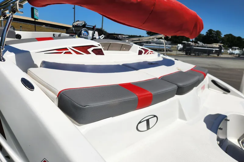 Slide: The Image of 2022 Tahoe T18 boat with red and gray seating, docked outdoors. - 10