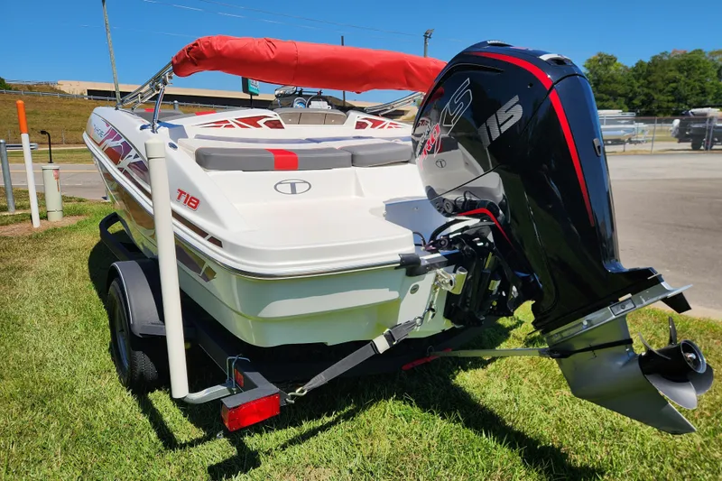 Slide: The Image of 2022 Tahoe T18 boat with outboard motor on a trailer, parked on grass. - 4