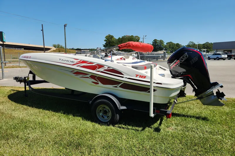Slide: The Image of 2022 Tahoe T18 boat with red graphics on a trailer, parked on grass. - 5