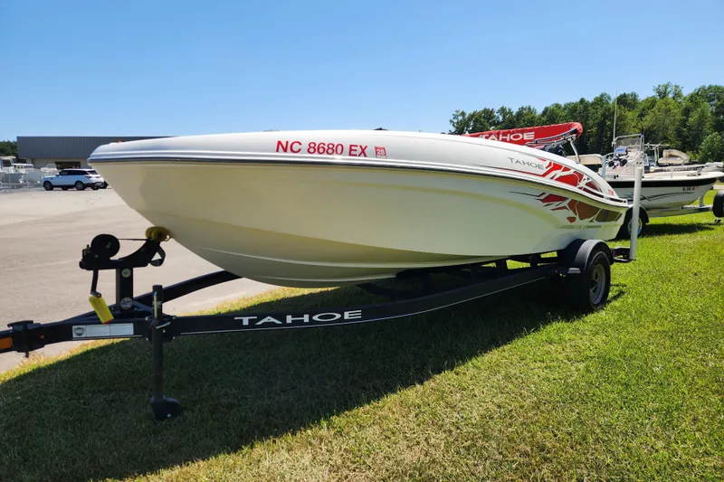 Slide: The Image of 2022 Tahoe T18 boat on trailer, parked on grass under clear blue sky. - 7