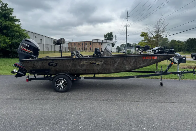 Slide: The Image of 2021 G3 Sportsman 1710 Camo boat with Yamaha motor on trailer, parked outdoors. - 1