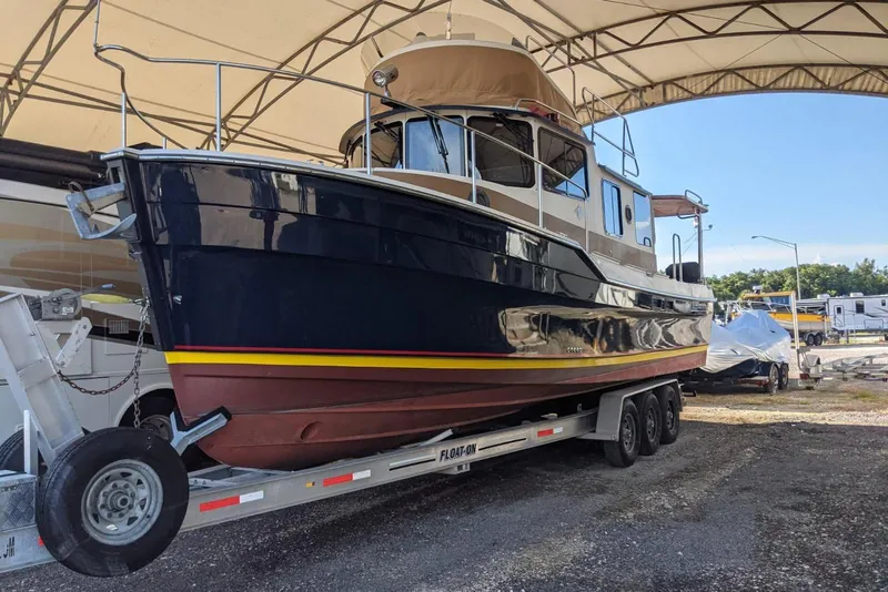 Slide: The Image of 2014 Ranger Tugs R-31 CB boat on trailer under canopy. - 3