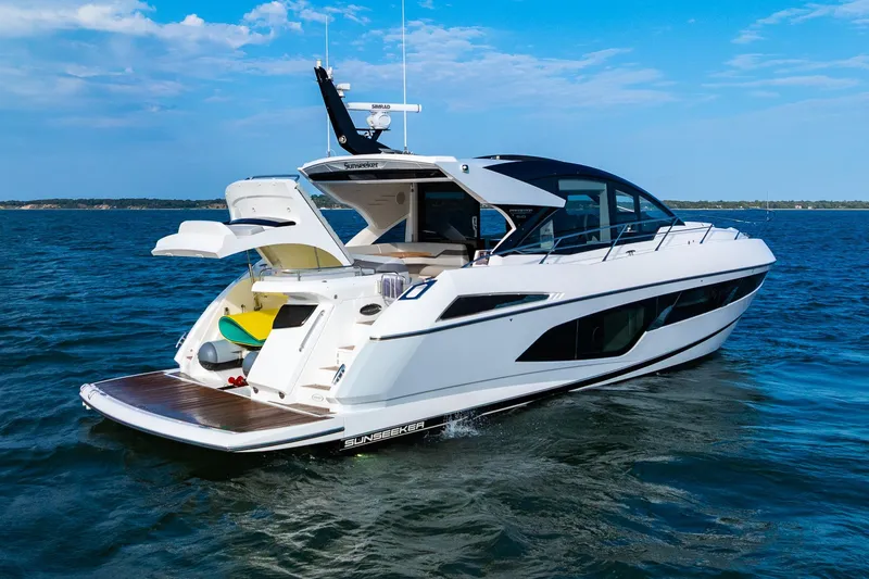 Slide: The Image of 2021 Sunseeker 60 Evo yacht cruising on open water under a clear blue sky. - 14