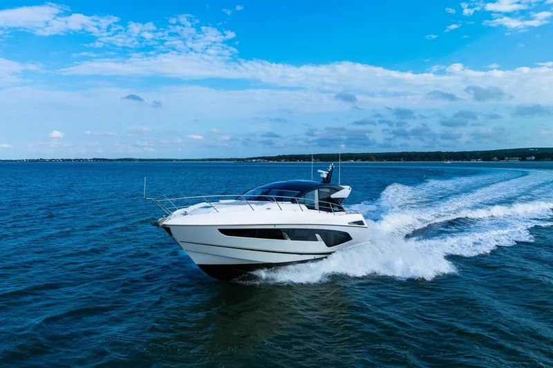 Slide: The Image of 2021 Sunseeker 60 Evo yacht cruising on open blue waters under a clear sky. - 19