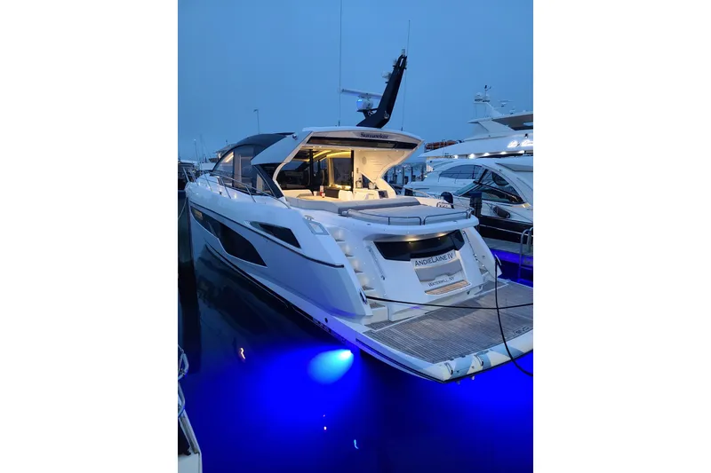 Slide: The Image of 2021 Sunseeker 60 Evo yacht cruising on open water under a blue sky. - 2