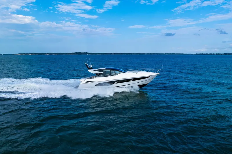 Slide: The Image of 2021 Sunseeker 60 Evo yacht cruising on open blue sea under clear sky. - 20
