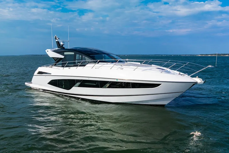 Slide: The Image of 2021 Sunseeker 60 Evo yacht cruising on open water under a clear blue sky. - 7