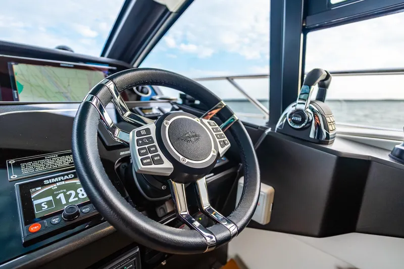 Slide: The Image of Cockpit of 2021 Sunseeker 60 Evo yacht with steering wheel and navigation controls. - 70