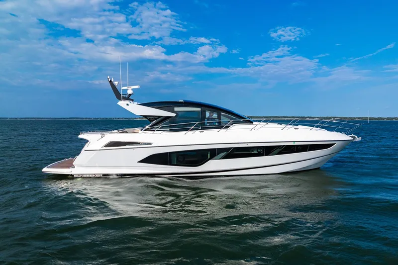 Slide: The Image of 2021 Sunseeker 60 Evo yacht cruising on open water under a clear blue sky. - 8