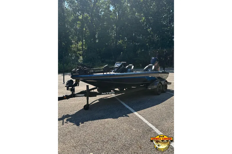 Slide: The Image of 2024 Nitro Z21 XL boat parked in a sunlit area with trees in the background. - 4