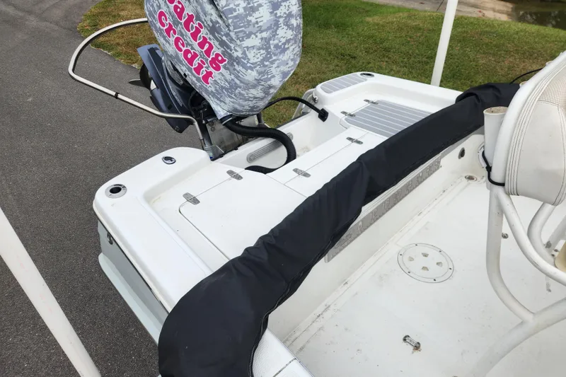 Slide: The Image of 2019 BlackJack 224 boat with white seating and Suzuki engine in a marina. - 12