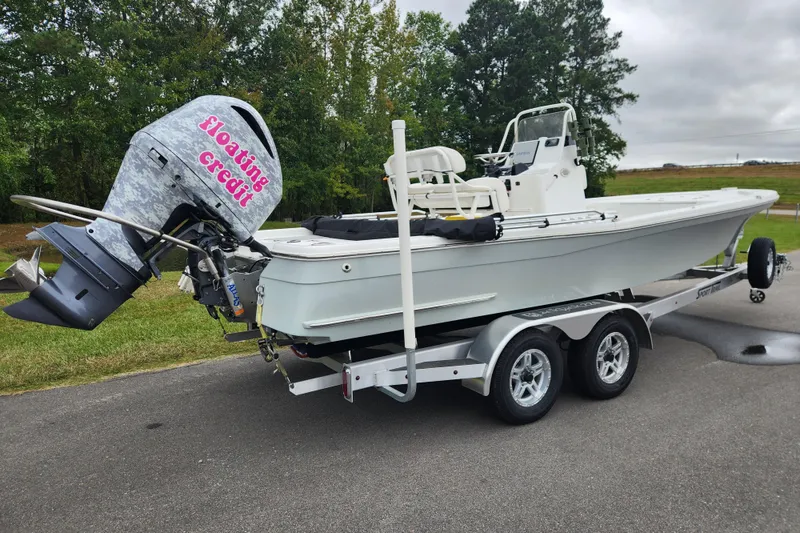 Slide: The Image of 2019 BlackJack 224 boat on trailer with Yamaha outboard motor, parked outdoors. - 2