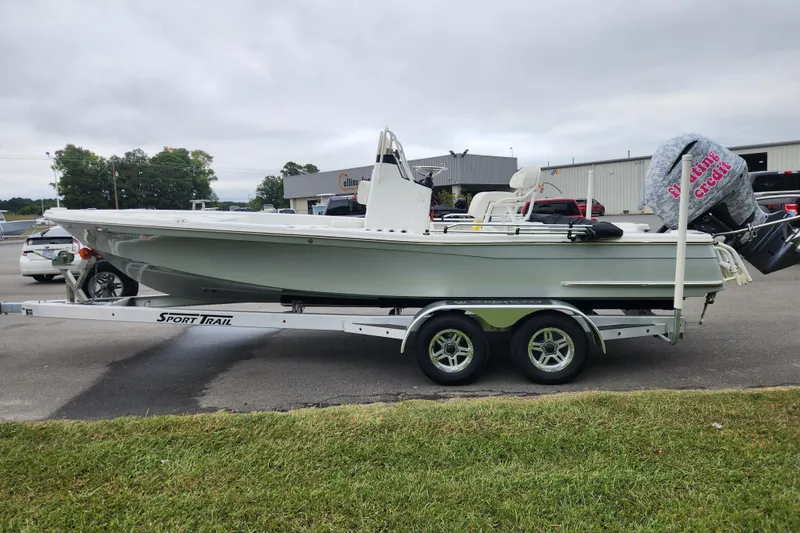 Slide: The Image of 2019 BlackJack 224 boat on Sport Trail trailer, parked on grass under clear blue sky. - 6