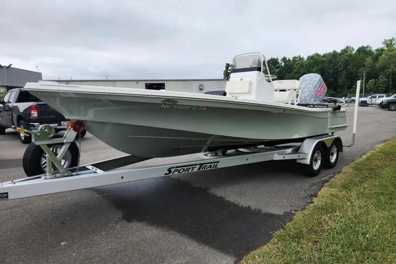 Slide: The Image of 2019 BlackJack 224 boat on Sport Trail trailer, parked on grass under clear blue sky. - 7