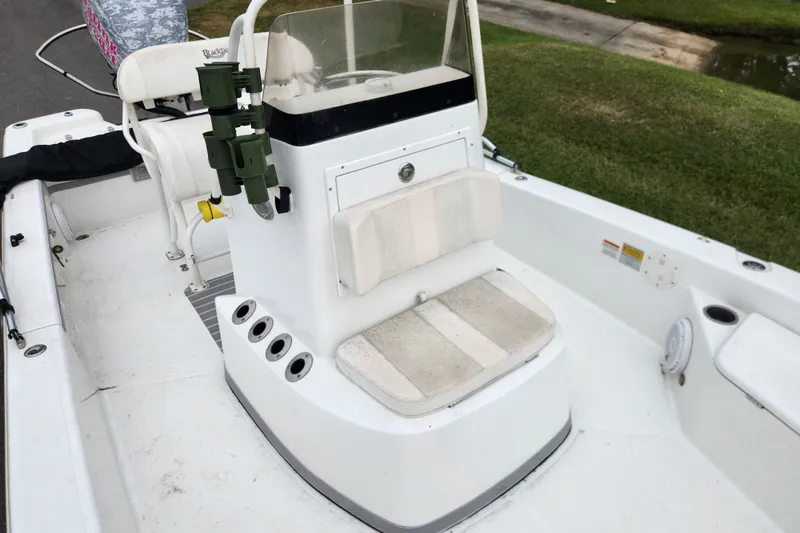 Slide: The Image of 2019 BlackJack 224 boat on trailer in parking lot with trucks and trees. - 9