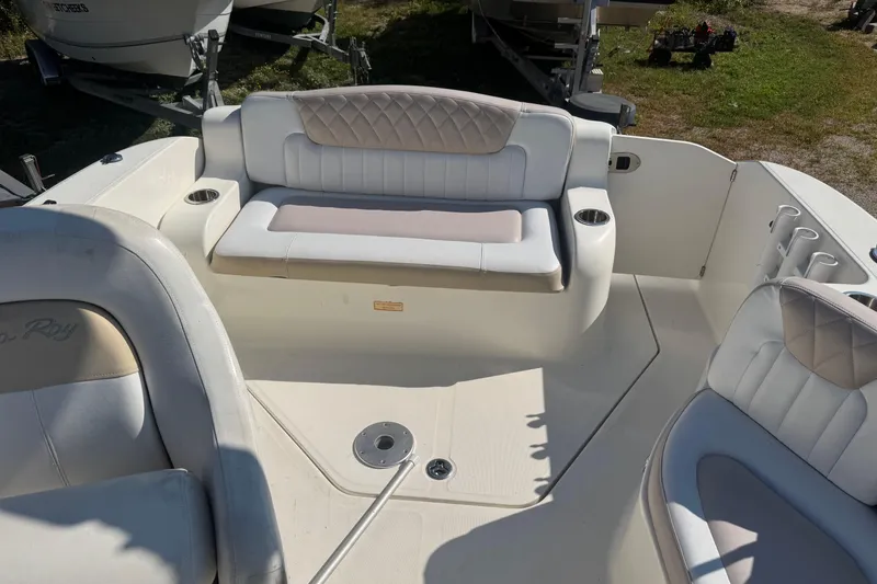 Slide: The Image of 2009 Sea Ray 230 Sundancer boat interior with white seating and cup holders. - 10