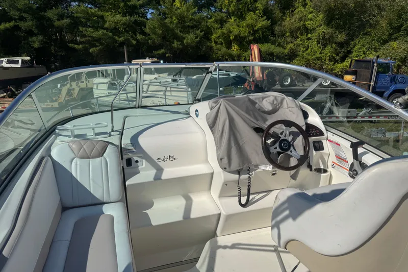 Slide: The Image of 2009 Sea Ray 230 Sundancer boat interior with steering wheel and seating. - 11