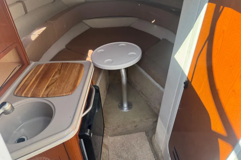 Slide: The Image of 2009 Sea Ray 230 Sundancer cabin interior with kitchenette and seating area. - 12
