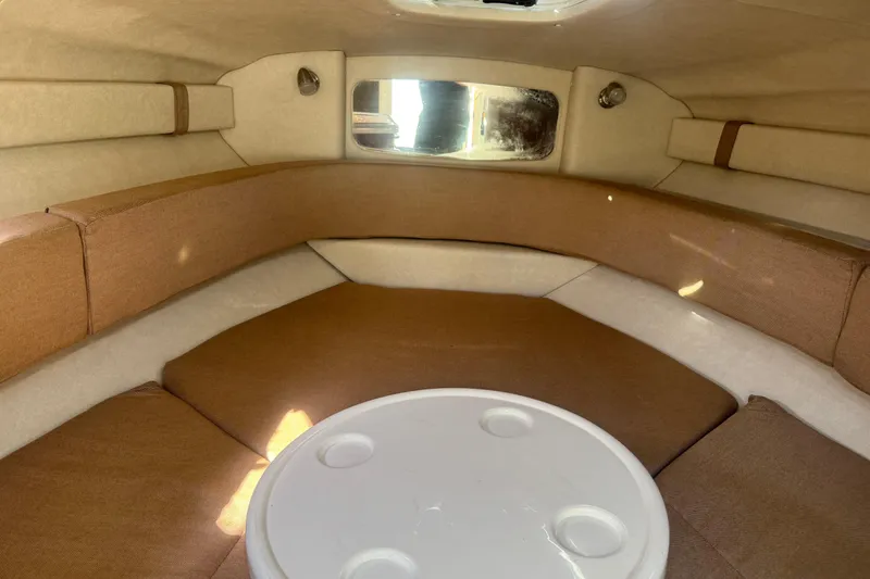 Slide: The Image of Interior cabin of 2009 Sea Ray 230 Sundancer with cushioned seating and table. - 13