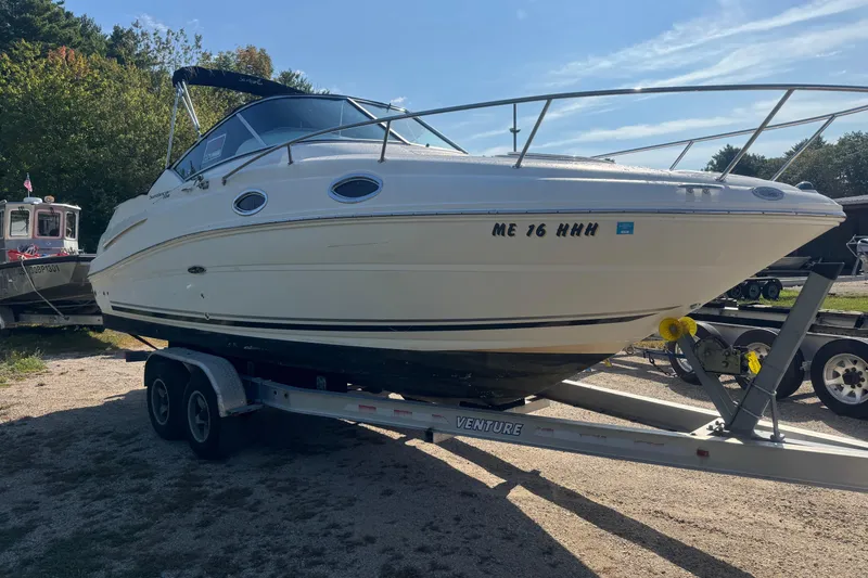 Slide: The Image of 2009 Sea Ray 230 Sundancer boat on trailer, parked outdoors under clear sky. - 15
