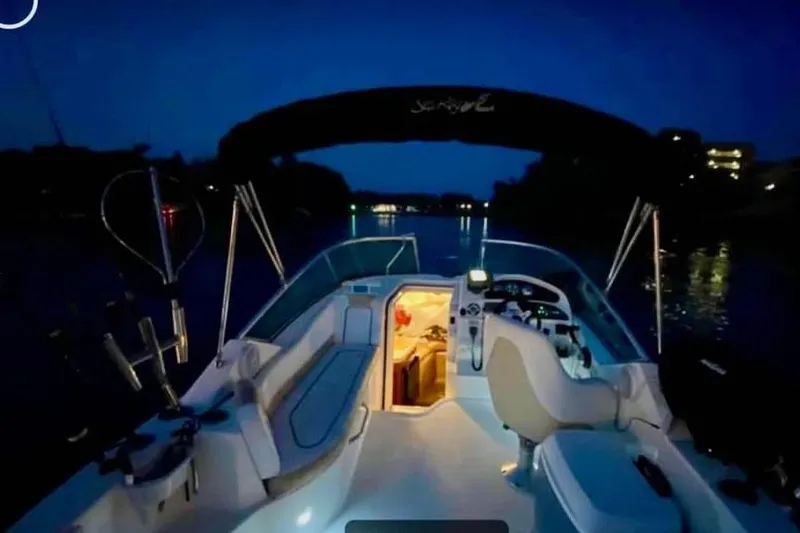 Slide: The Image of 2009 Sea Ray 230 Sundancer boat interior illuminated at night on calm water. - 2