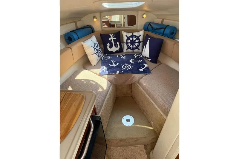 Slide: The Image of Interior of 2009 Sea Ray 230 Sundancer with nautical-themed cushions and cozy seating. - 4