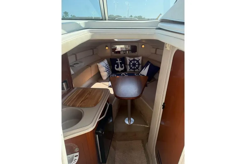 Slide: The Image of Interior of 2009 Sea Ray 230 Sundancer boat with cozy seating and nautical decor. - 5