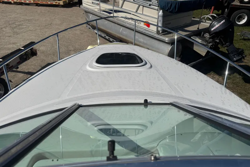 Slide: The Image of 2009 Sea Ray 230 Sundancer boat deck with hatch, parked near other boats. - 9