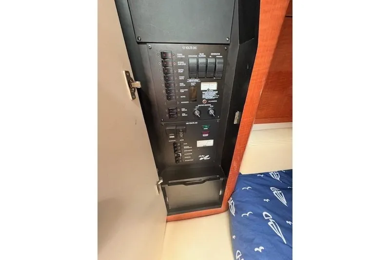 Slide: The Image of Electrical panel inside 2004 Sea Ray 320 Sundancer boat cabin, featuring switches and controls. - 15