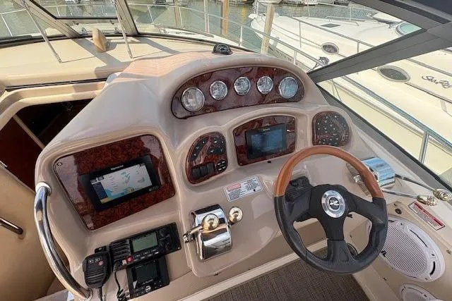 Slide: The Image of 2004 Sea Ray 320 Sundancer helm with navigation instruments and steering wheel. - 9