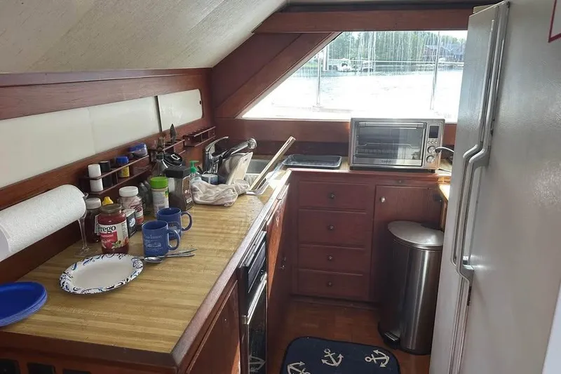 Slide: The Image of 1975 Pacemaker 62 Motor Yacht kitchen with wooden cabinets, countertop, and appliances. - 10