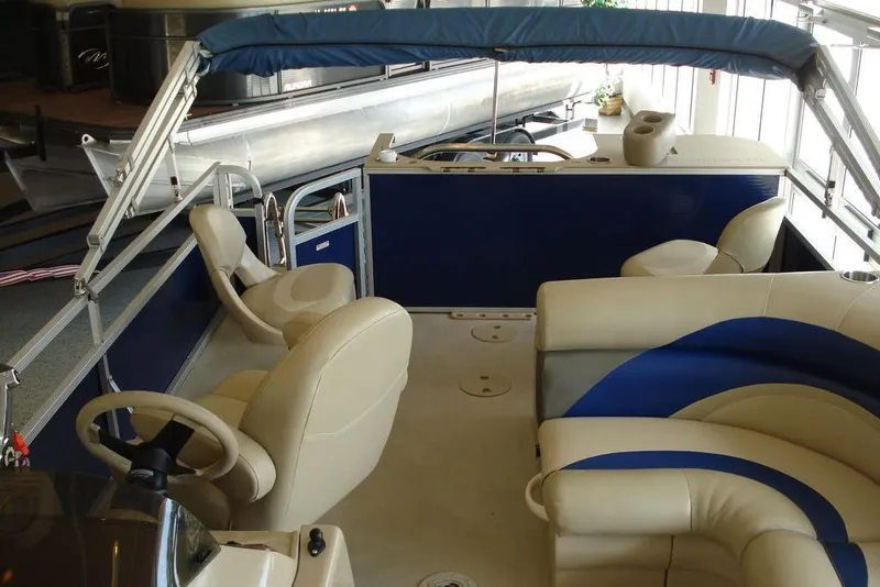 Slide: The Image of 2013 Manitou Aurora 22 VP pontoon boat interior with beige and blue seating. - 5