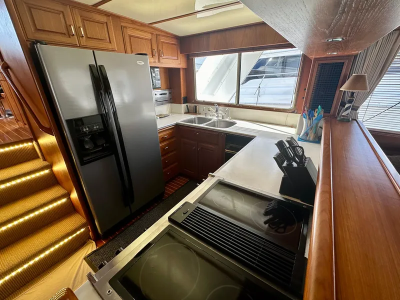 Slide: The Image of 1987 Tollycraft Pilothouse Motor Yacht kitchen with modern appliances and wooden cabinetry. - 10