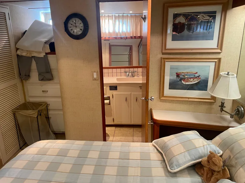 Slide: The Image of 1987 Tollycraft Pilothouse Motor Yacht bedroom with ensuite bathroom, nautical decor, and cozy bedding. - 17