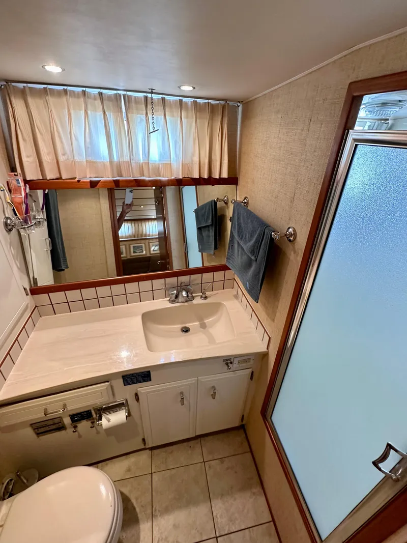 Slide: The Image of 1987 Tollycraft Pilothouse Motor Yacht bathroom with sink, mirror, and shower. - 18