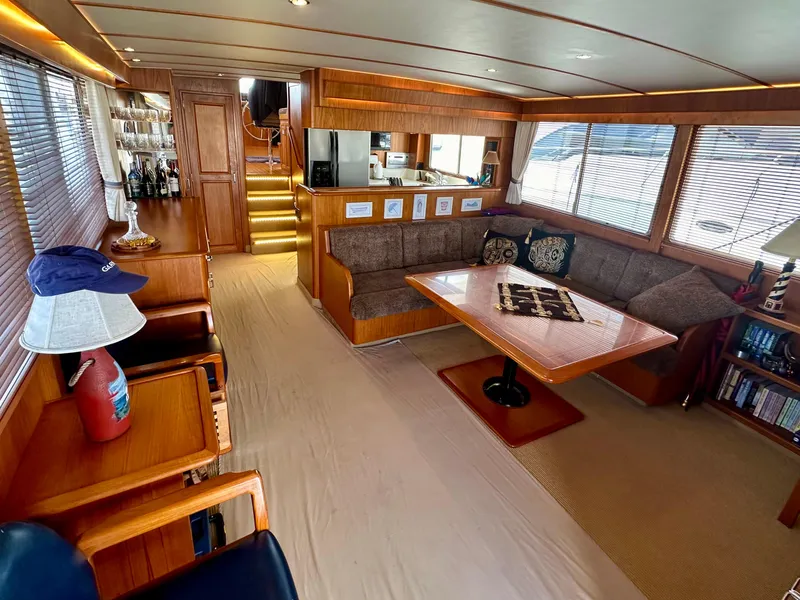 Slide: The Image of 1987 Tollycraft Pilothouse Motor Yacht interior with cozy seating and wooden accents. - 2