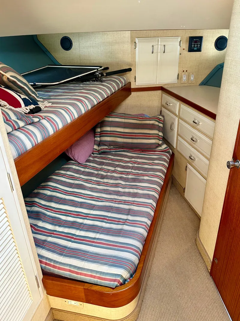 Slide: The Image of 1987 Tollycraft Pilothouse Motor Yacht cabin with bunk beds and striped bedding. - 21