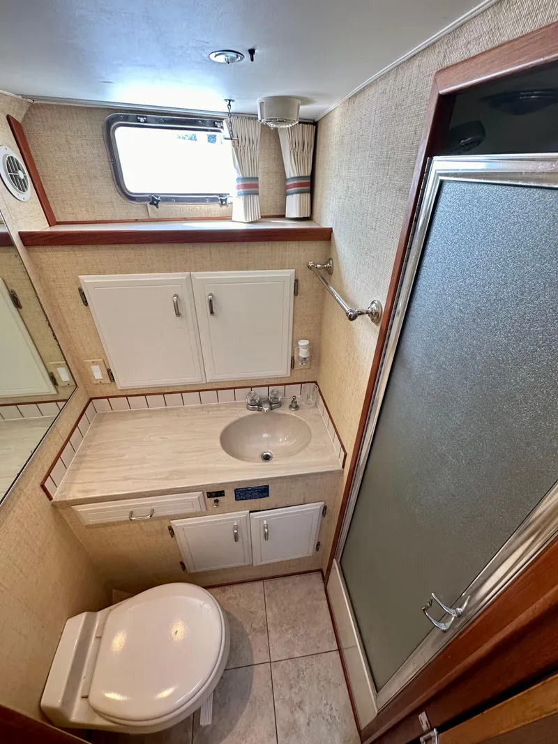 Slide: The Image of 1987 Tollycraft Pilothouse Motor Yacht bathroom with shower, sink, and toilet. - 23