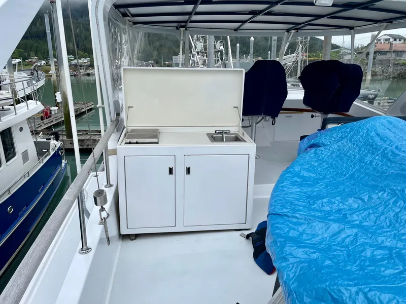 Slide: The Image of 1987 Tollycraft Pilothouse Motor Yacht deck with covered seating and kitchenette area. - 25