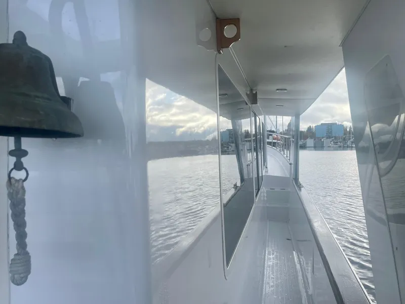 Slide: The Image of 1987 Tollycraft Pilothouse Motor Yacht deck view with bell, reflecting water and sky. - 26