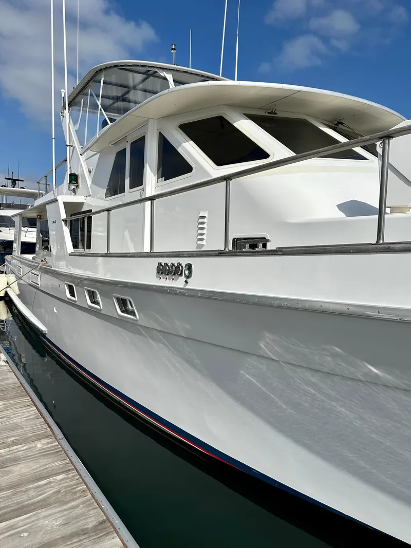 Slide: The Image of 1987 Tollycraft Pilothouse Motor Yacht docked, showcasing sleek white design under blue sky. - 27