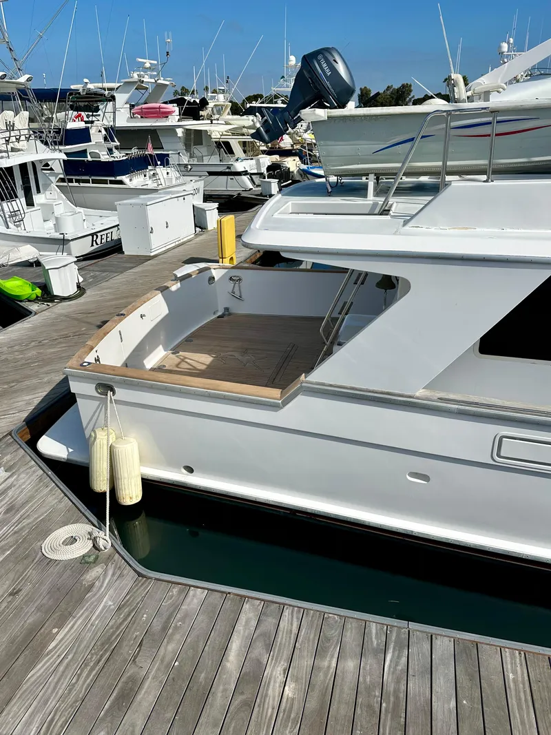 Slide: The Image of 1987 Tollycraft Pilothouse Motor Yacht docked at marina, showcasing sleek design and spacious deck. - 32